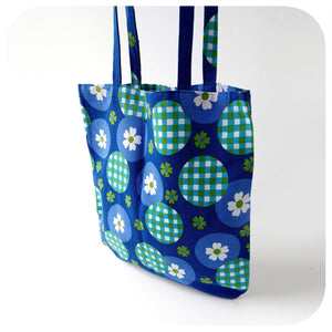 Blue tote bag with green and white pattern on a white background