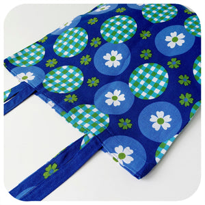 Blue vintage fabric tote bag with floral and checkered patterns on a white background