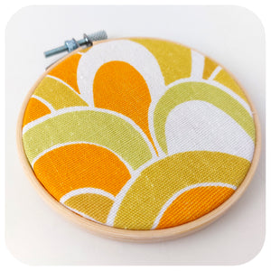 Vintage fabric framed in an embroidery hoop, featuring 70s swirl pattern in orange, yellow and green | The Inkabilly Emporium