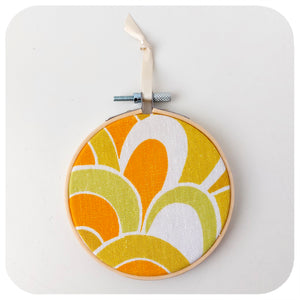 Vintage fabric framed in an embroidery hoop, featuring 70s swirl pattern in orange, yellow and green | The Inkabilly Emporium