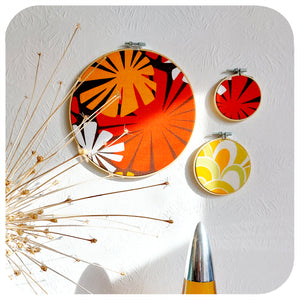 A trio of Vintage Fabric Embroidery Hoops on a white wall