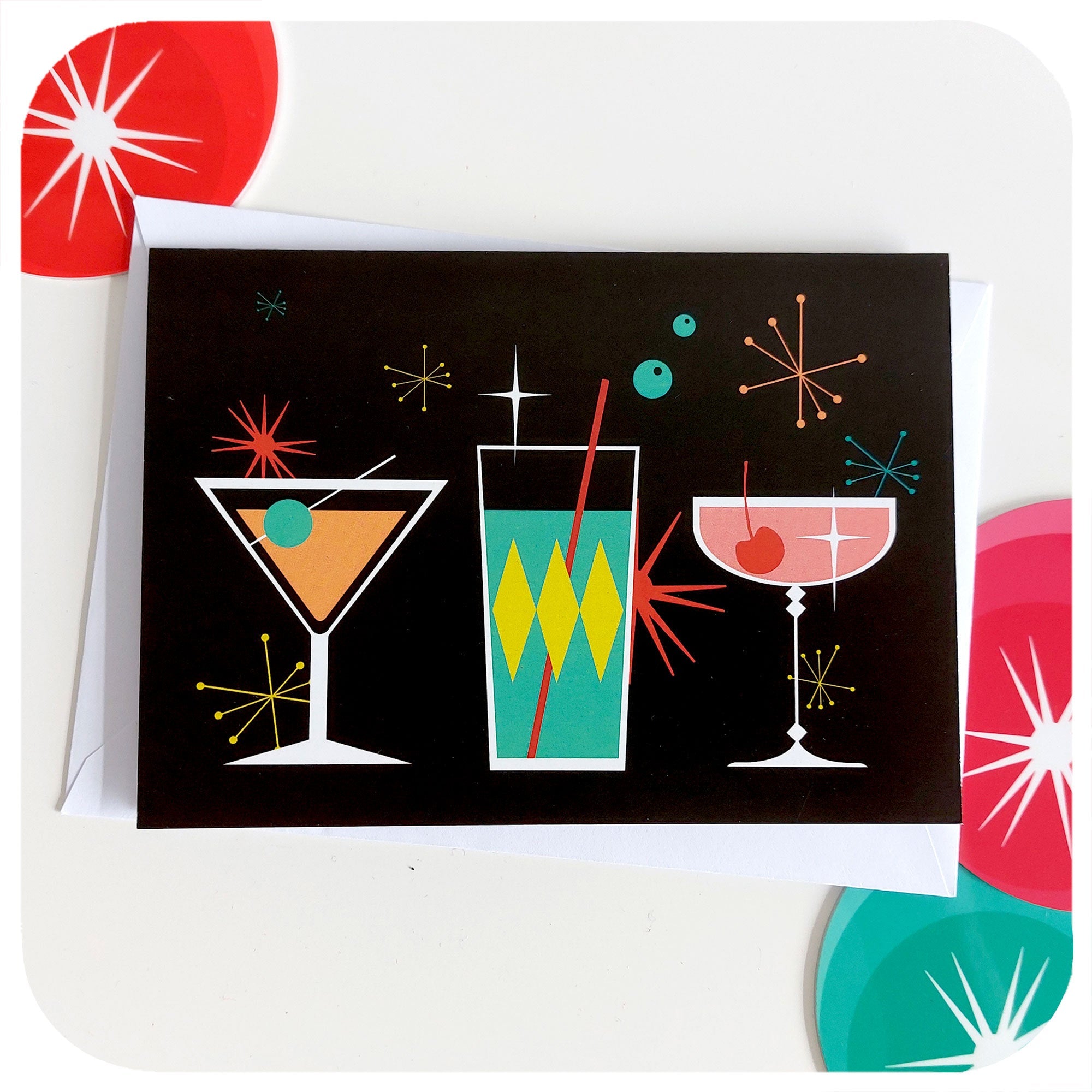 Cosmic Cocktails Greetings Card,  on a table with white envelope behind and retro decorations in background | The Inkabilly Emporium