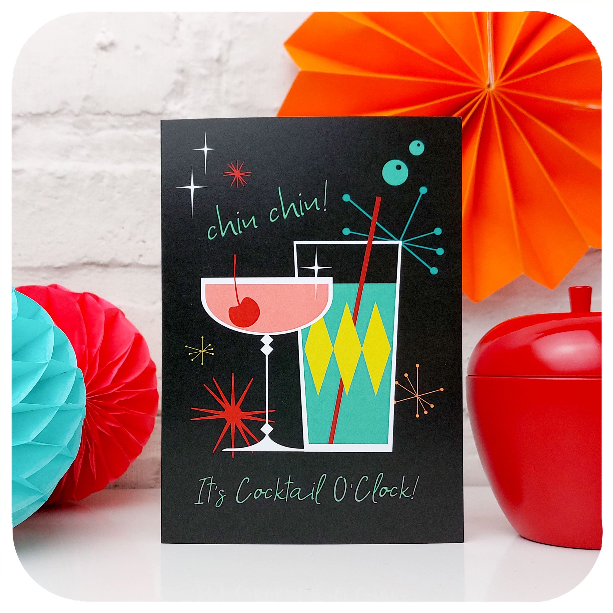 Chin Chin! It's Cocktail O'Clock Greetings Card standing in front of retro party decorations | The Inkabilly Emporium