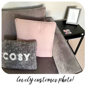 Customer photo of Pink Scandi Coaster on black side table next to grey sofa with pink and grey cushions.