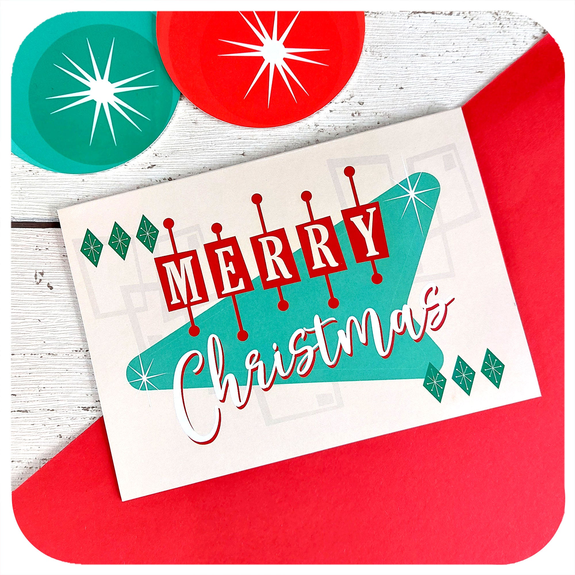 Atomic Style Christmas Card on a red & white background with retro xmas decorations. Text on the card reads "Merry Christmas" | The Inkabilly Emporium