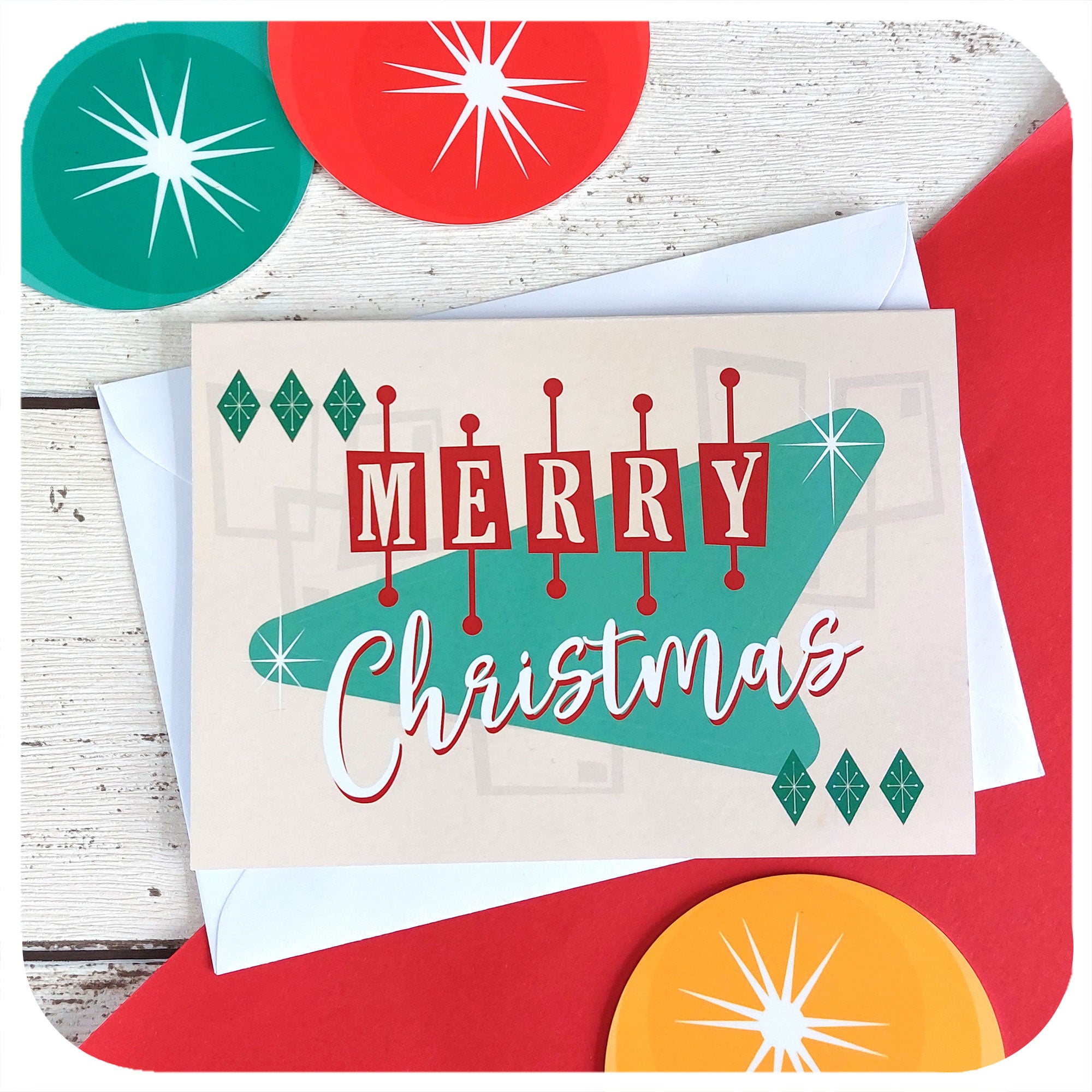 Atomic Style Christmas Card with envelope, on a red & white background with retro xmas decorations. Text on the card reads "Merry Christmas" | The Inkabilly Emporium