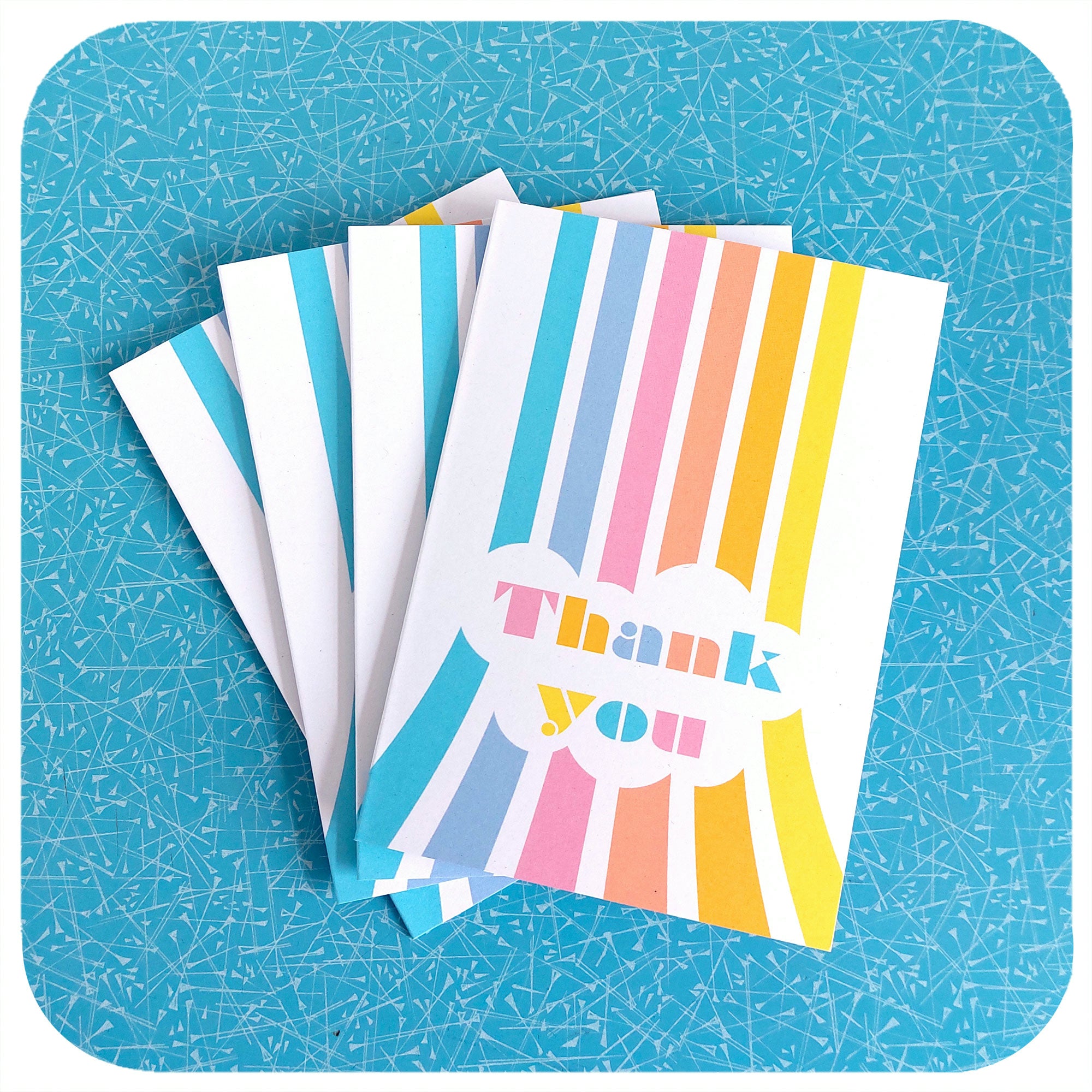 Four Thank You Cards featuring retro pastel rainbows, on a blue table | The Inkabilly Emporium