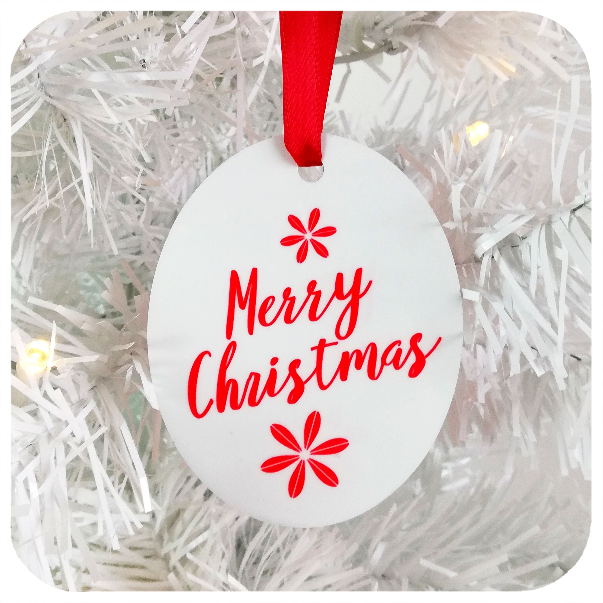 Christmas Tree Decoration saying Merry Christmas in red & white, hanging by red ribbon on a white Christmas tree | The Inkabilly Emporium